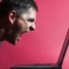 Man shouting at a laptop screen.