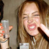 Person making a funny face holding drinks.