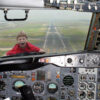 Child on airplane windshield, cockpit view.