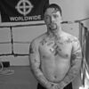 Man with tattoos in a boxing ring.