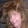 Woman with messy hair smiling widely.