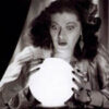 Woman gazing into a glowing crystal ball.
