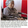 Elderly woman in a wheelchair, wearing patterned outfit.