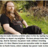 Man sitting on grass with humorous sign.