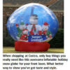 Inflatable snow globe with snowmen outdoors.