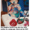 Child covered in paint, sitting on floor.