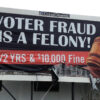 Billboard warning about voter fraud penalties.