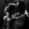 Bride and groom embracing in romantic moment.