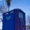 Portable toilet with smoke rising above it.